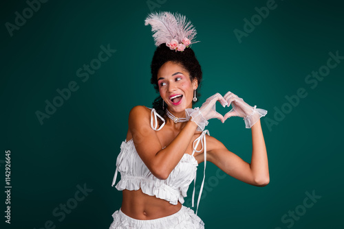 Playful young woman in elegant white costume against green background photo