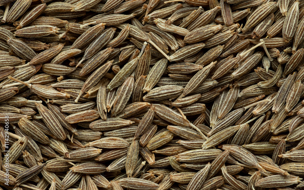 Close-up view of whole cumin (Cuminum cyminum) seeds. Abstract food texture. Close-up view of whole cumin (Cuminum cyminum) seeds. Abstract food texture.