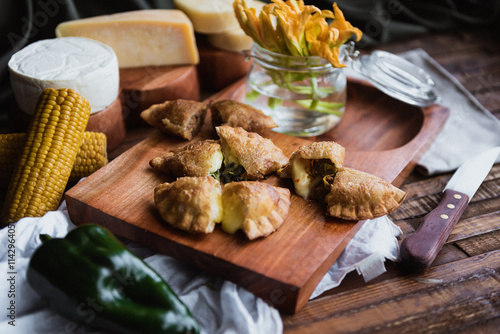 cheese empanadas cut in half served on wooden board