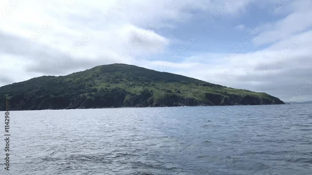 Small Island in the sea in summer, view from a speedboat with splashing waves, marine tourism, marine nature reserve, ecology and environmental issues. Tourism and summer vacations Small Island in the sea in summer, view from a speedboat with splashing waves, marine tourism, marine nature reserve, ecology and environmental issues. Tourism and summer vacations