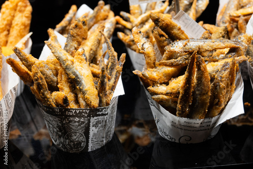 Crispy fried anchovies or sardines in a paper bag, Spanish street food.