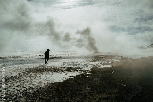 person walking by geysir in iceland photo