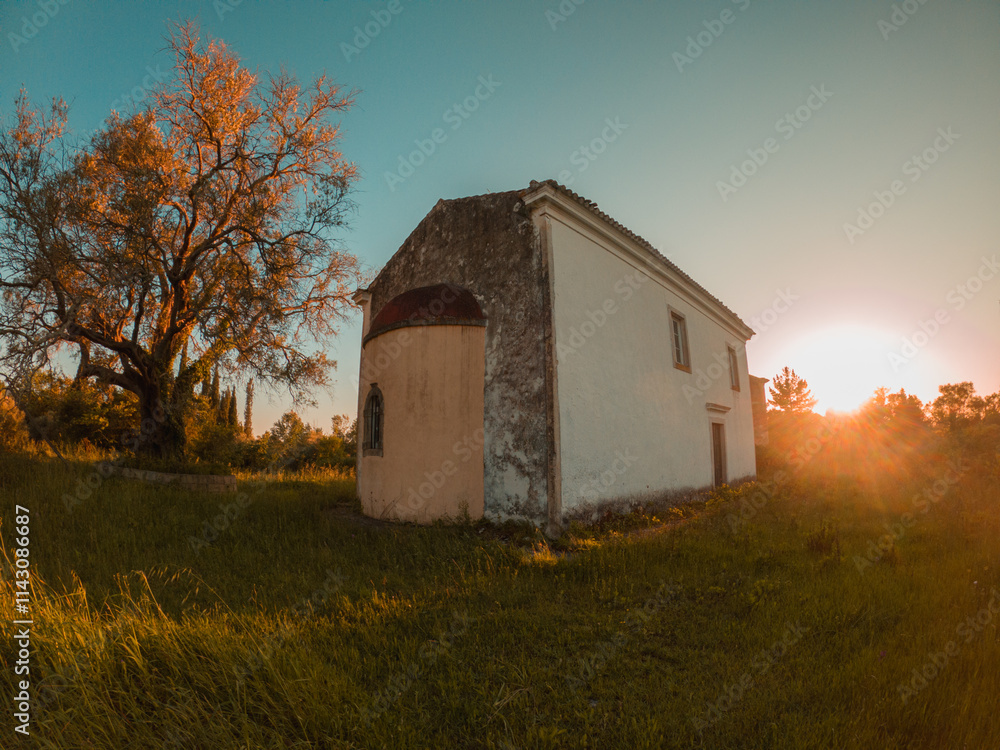 Old building at sunset beside a tree Old building at sunset beside a tree
