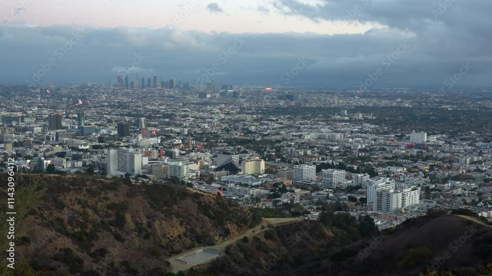 Wide-angle view of the sprawling Los Angeles cityscape from an elevated perspective, featuring cloudy skies. Wide-angle view of the sprawling Los Angeles cityscape from an elevated perspective, featuring cloudy skies.