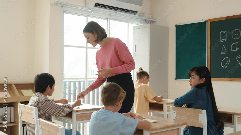Caucasian teacher walking and check student homework at classroom while diverse children doing classwork at classroom. Diverse smart student lecturing and taking a note at elementary school. Pedagogy. Caucasian teacher walking and check student homework at classroom while diverse children doing classwork at classroom. Diverse smart student lecturing and taking a note at elementary school. Pedagogy.