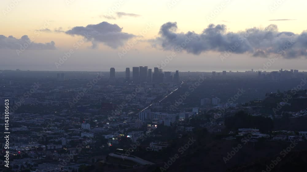 Evening view of Los Angeles under a twilight sky captured from Runyon Canyon, showcasing the city lights emerging. Evening view of Los Angeles under a twilight sky captured from Runyon Canyon, showcasing the city lights emerging.