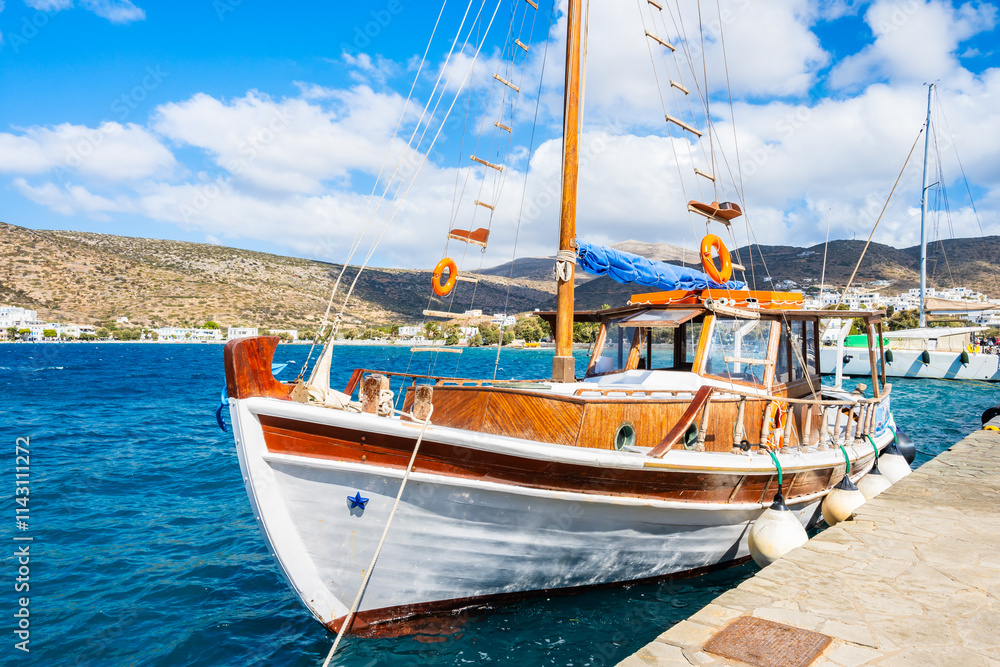 Traditional fishing boat anchoring in small port of Katapola village, Amorgos island, Cyclades, Greece