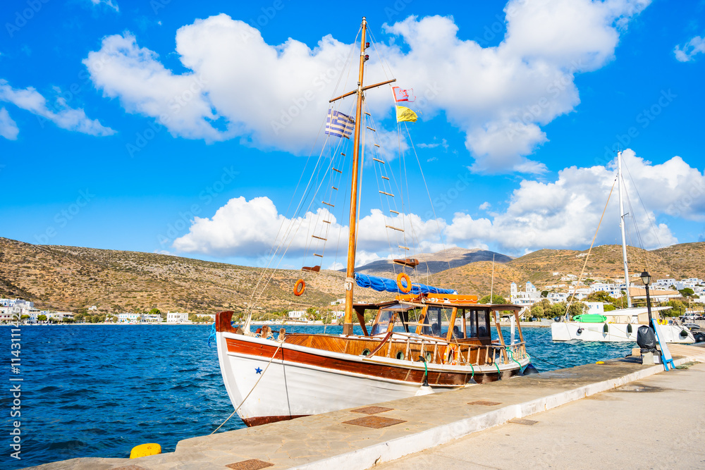 Traditional fishing boat anchoring in small port of Katapola village, Amorgos island, Cyclades, Greece
