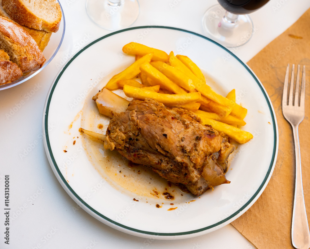 Fried knuckle (codillo rustido) with potatoes on plate Fried knuckle (codillo rustido) with potatoes on plate