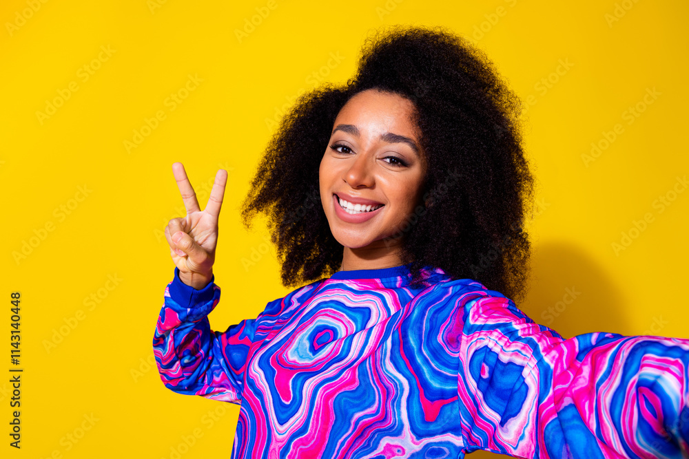 Photo portrait of pretty young girl take selfie photo v-sign wear trendy colorful blue outfit isolated on yellow color background Photo portrait of pretty young girl take selfie photo v-sign wear trendy colorful blue outfit isolated on yellow color background