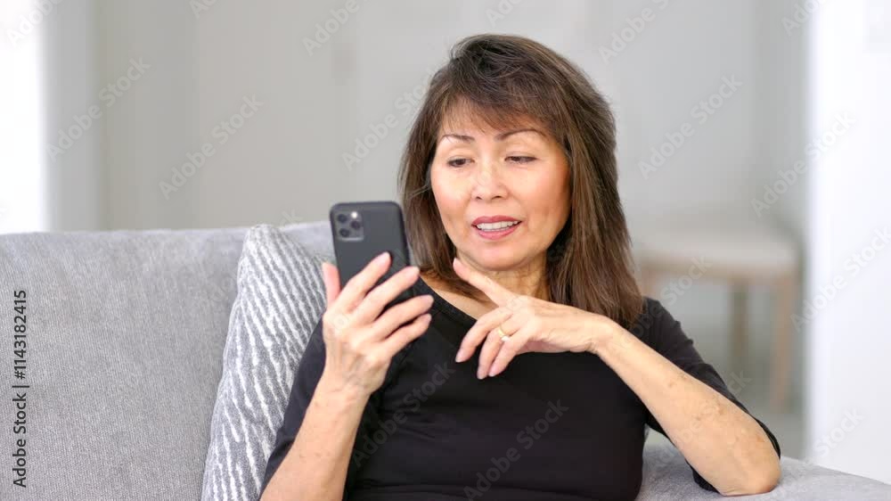 Woman enjoying video chatting on smartphone sitting on sofa closeup Woman enjoying video chatting on smartphone sitting on sofa closeup