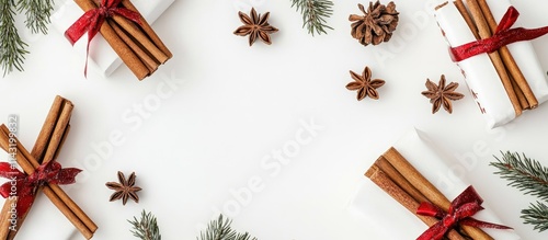 Festively arranged cinnamon sticks with red ribbons and natural decorations on a white background for holiday and seasonal themes photo