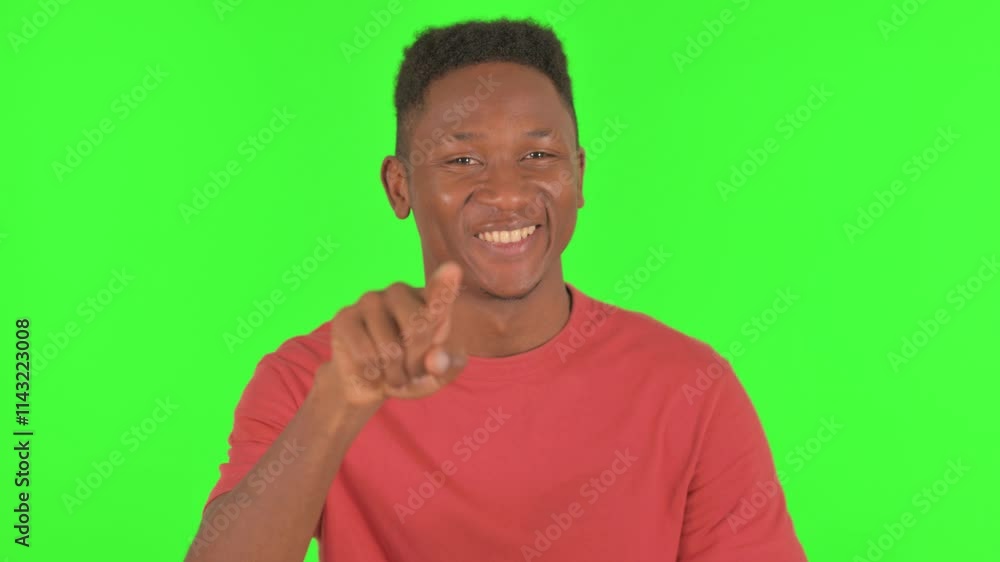 Portrait of African Man Pointing at Camera on Green Background