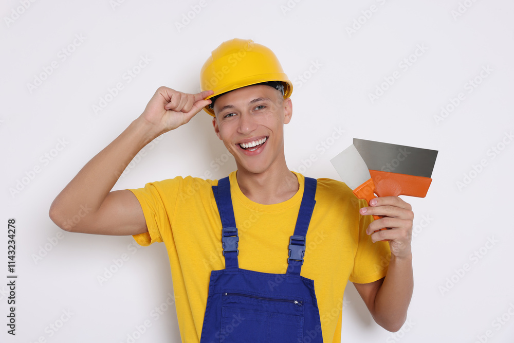 Portrait of young decorator with putty knives on white background Portrait of young decorator with putty knives on white background