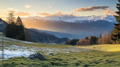 A serene landscape showcasing mountains at sunset with snow and lush green fields.