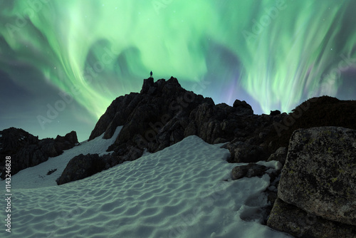 Northern lights over snowy mountain landscape photo