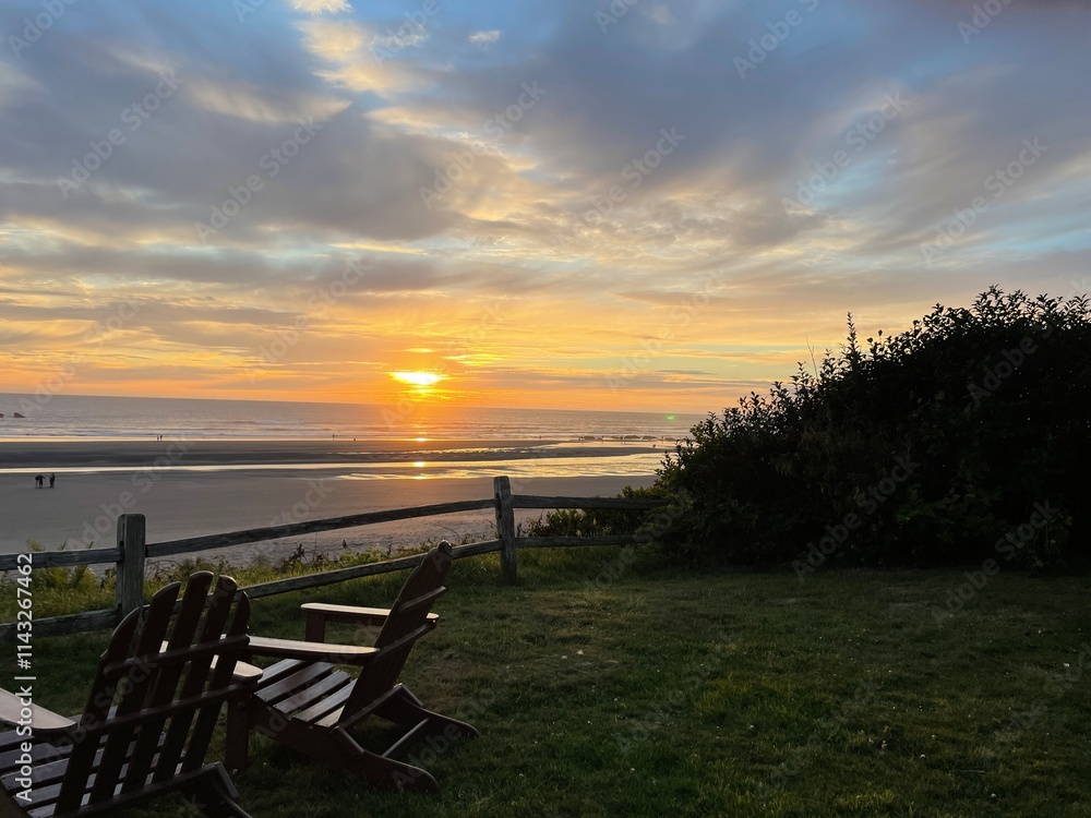 Fototapeta premium Sunset on the Pacific with Split Rail Fence and Adirondack Chairs