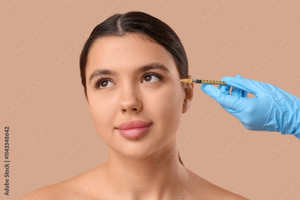 Young woman receiving filler injection in face on brown background Young woman receiving filler injection in face on brown background