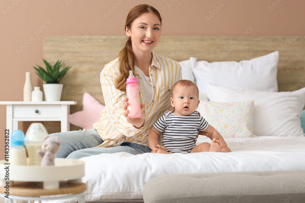Mother with bottle of milk and her little baby sitting in bedroom Mother with bottle of milk and her little baby sitting in bedroom