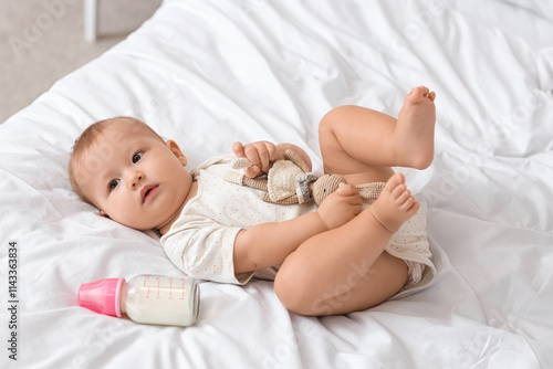 Cute baby with toy and bott...