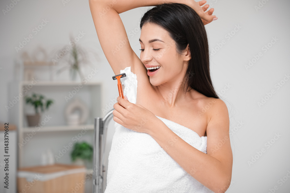 Beautiful young happy woman with razor and shaving foam on her armpit in bathroom Beautiful young happy woman with razor and shaving foam on her armpit in bathroom