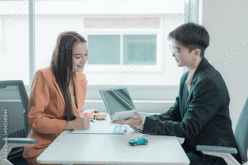 The person in question consults the car salesman with the purchase agreement for inspection at the showroom. The customer receives a vehicle purchase contract before signing with the dealer.