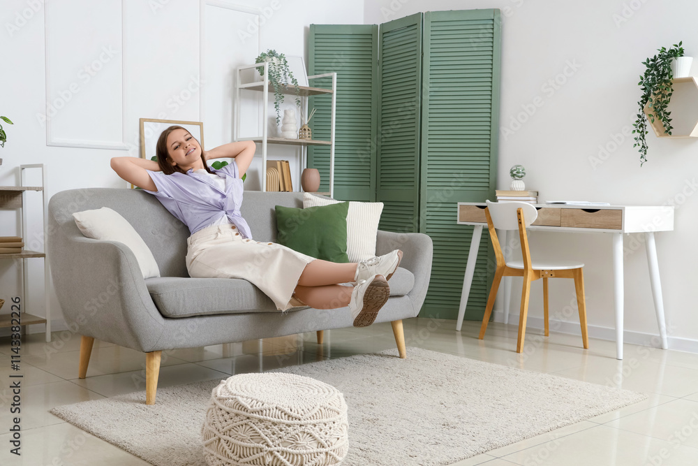 Young woman resting on grey couch at home Young woman resting on grey couch at home
