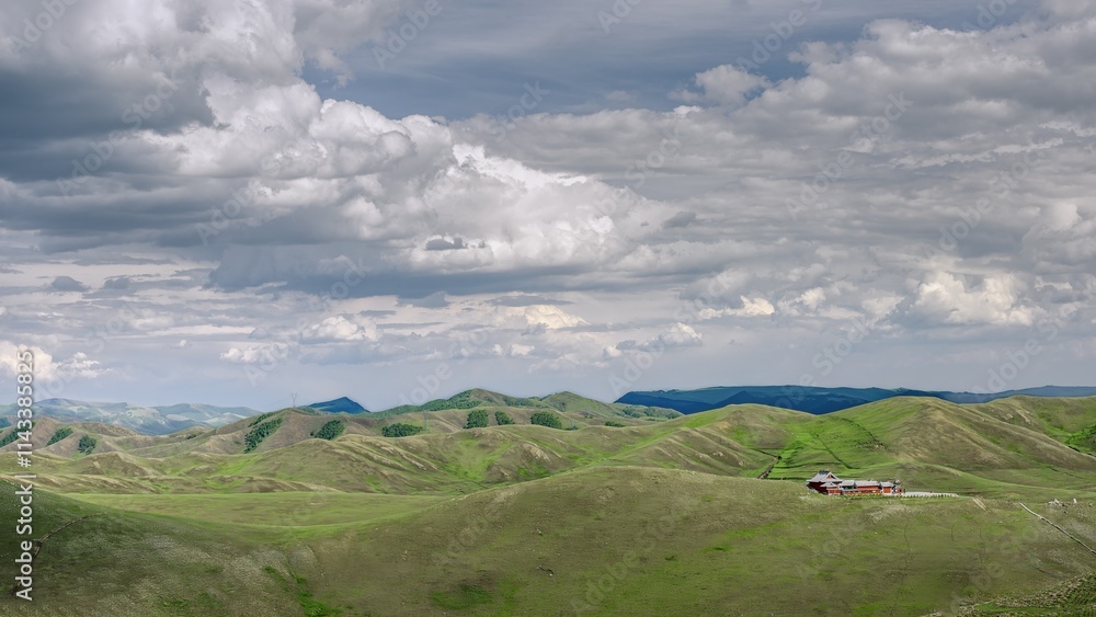 Fototapeta premium Vast summer landscape of Daqingshan Mountains featuring rolling hills and dramatic clouds in Inner Mongolia