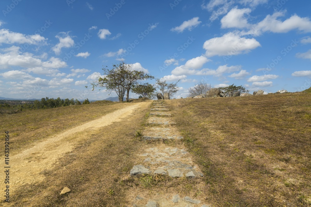 Fototapeta premium Exploring the ancient Xieng Khouang stone tank plains in Laos under a clear blue sky and minimal vegetation