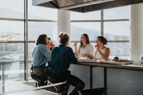A group of colleagues sit at a kitchen counter in the office, enjoying a lunch break together. They are engaged in conversation, creating a harmonious and relaxing atmosphere.