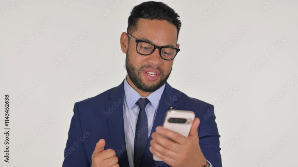 Portrait of Young Hispanic Businessman Doing Video Chat via Phone on White Background Portrait of Young Hispanic Businessman Doing Video Chat via Phone on White Background
