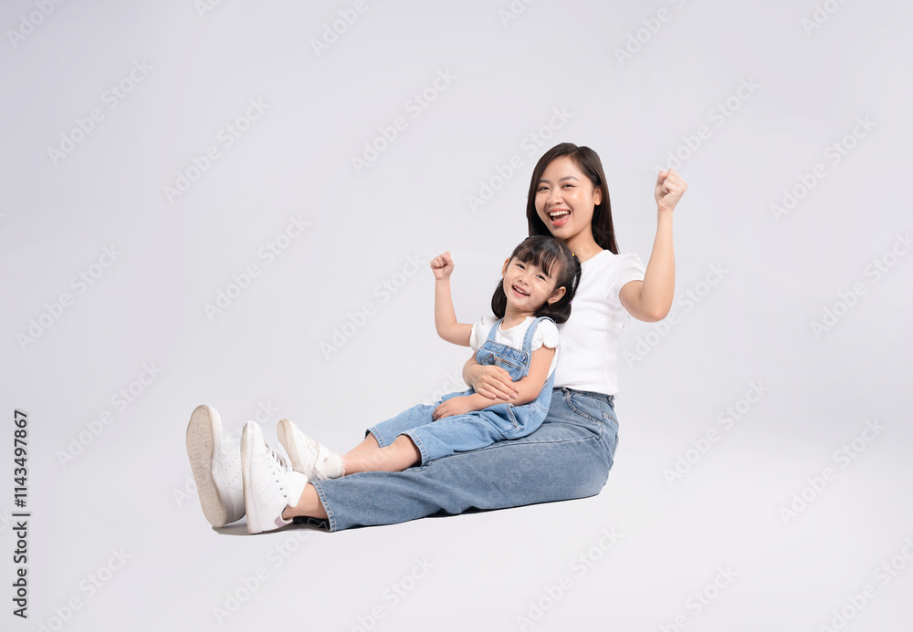 Full body image of Asian mother and daughter posing on white background Full body image of Asian mother and daughter posing on white background