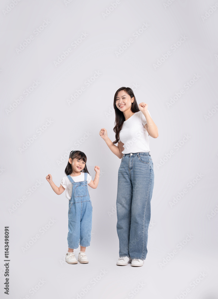 Full body image of Asian mother and daughter posing on white background Full body image of Asian mother and daughter posing on white background