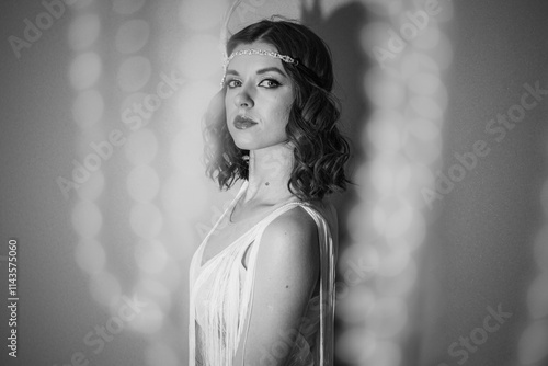 Black and white photo of a beautiful girl with hair and makeup in retro style
