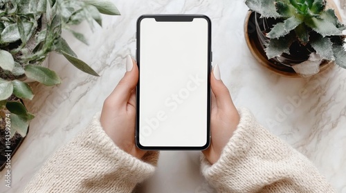 Woman seated, holding a mobile phone with a blank screen.