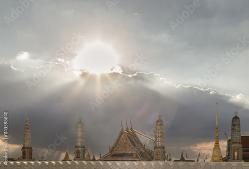 Beautiful Thai architecture of The Buddhist Temple of the Emerald Buddha Temple (Wat Phra Kaew) against the background of cloudy blue sky. It is also a potent religion symbolic and a famous tourist.