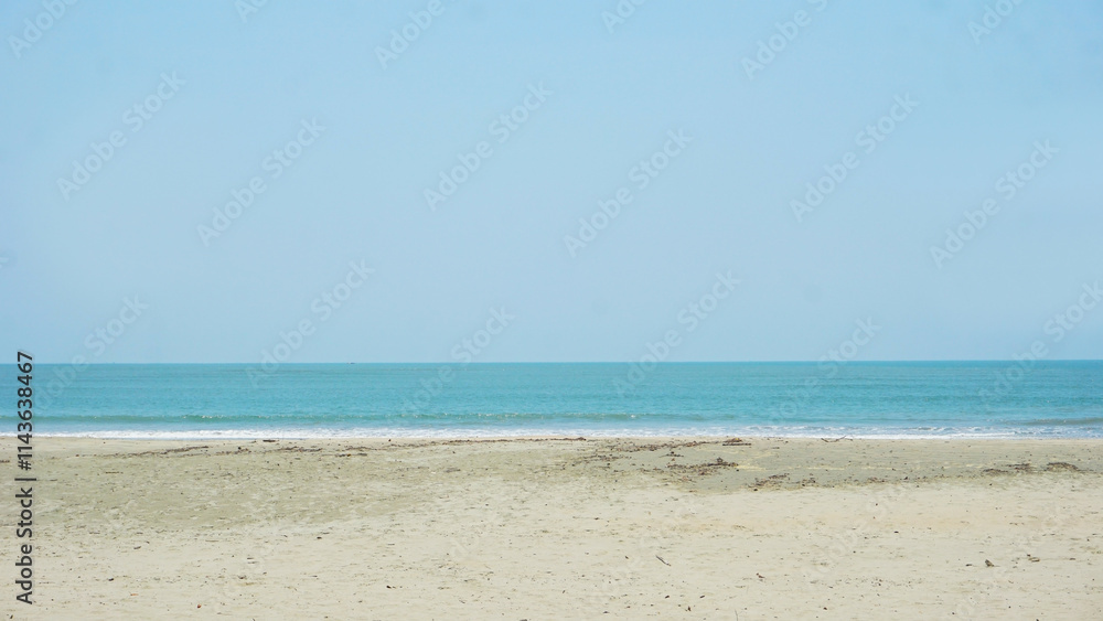 Tranquil Beachscape: Serene coastal view of a calm ocean meeting a sandy shore under a clear, pale blue sky. Perfect for evoking peace and relaxation. Tranquil Beachscape: Serene coastal view of a calm ocean meeting a sandy shore under a clear, pale blue sky. Perfect for evoking peace and relaxation.