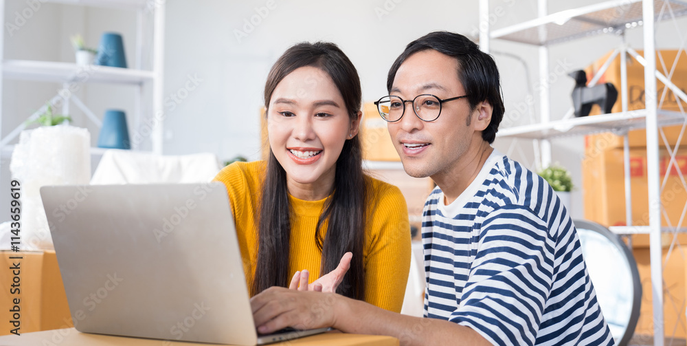 Asian couple sitting in home undergoing renovation, working together to choose furniture, wall colors, and decorations using a laptop. home, savings, loans, decoration, dreams concept. Asian couple sitting in home undergoing renovation, working together to choose furniture, wall colors, and decorations using a laptop. home, savings, loans, decoration, dreams concept.