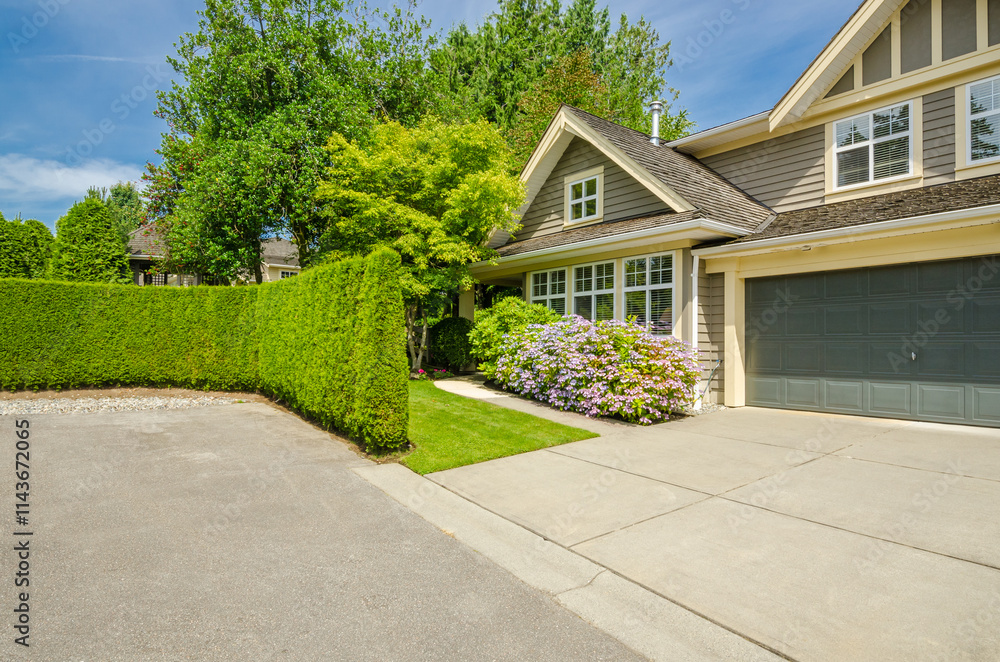 Garage door in luxury house with trees and nice landscape in Summer in Vancouver, Canada, North America. Day time on June 2024. Garage door in luxury house with trees and nice landscape in Summer in Vancouver, Canada, North America. Day time on June 2024.