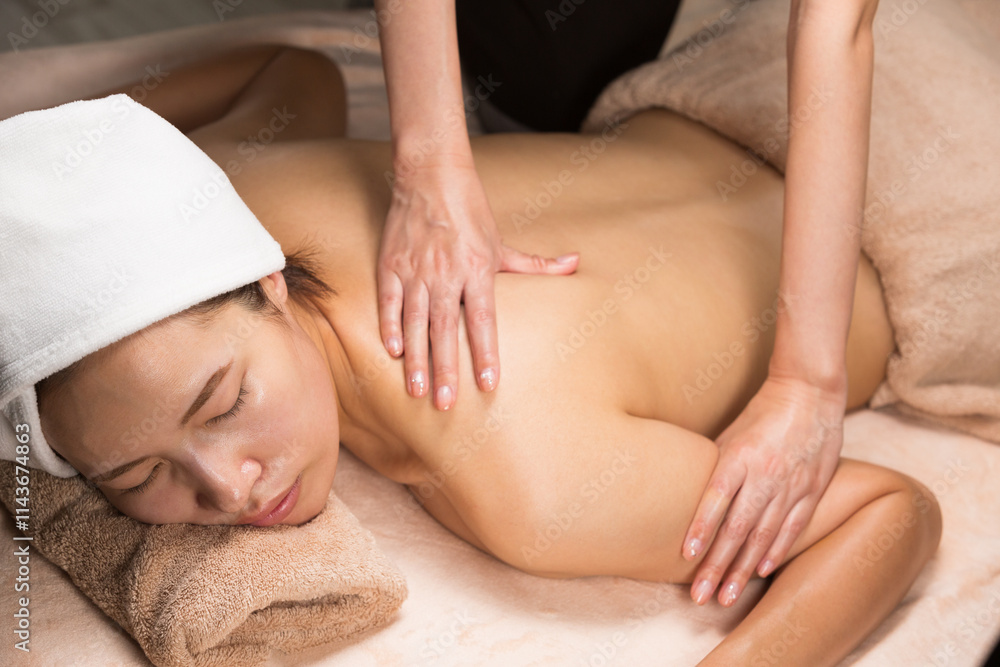 Fototapeta premium 若いアジア人女性は背中のオイルマッサージを受けています.