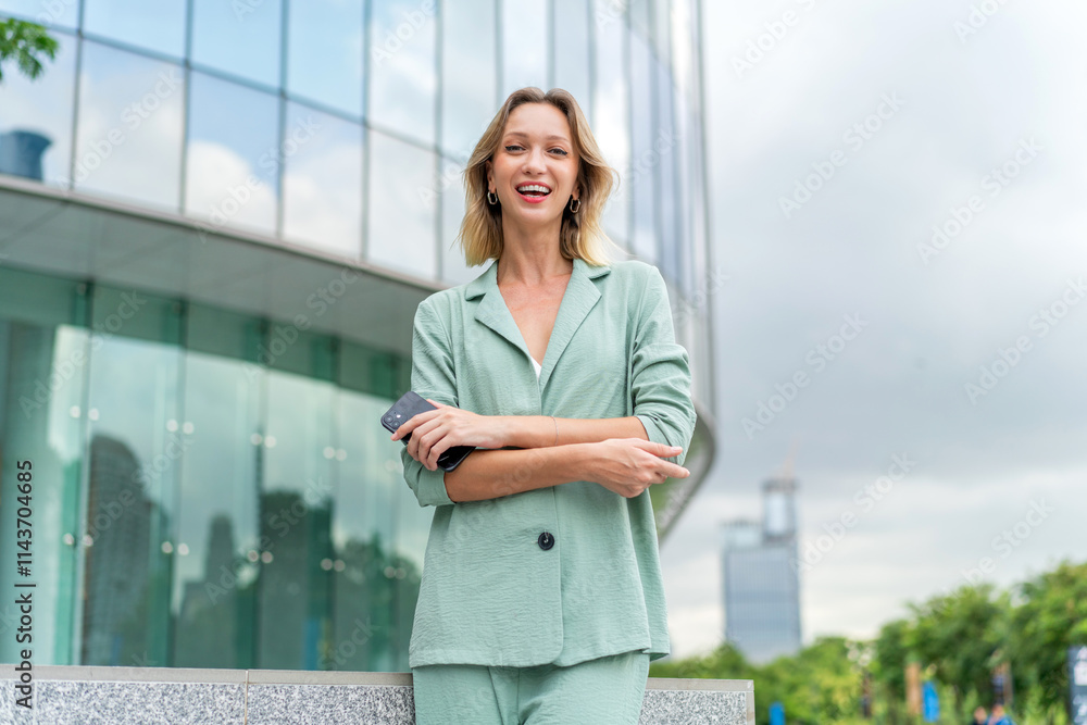 White Businesswoman Using Phone Outdoors In Front a Modern Glass Office Buildings White Businesswoman Using Phone Outdoors In Front a Modern Glass Office Buildings