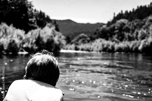 Selective focus on a child rafting down the wild and scenic Rogue River while wearing a life jacket photo