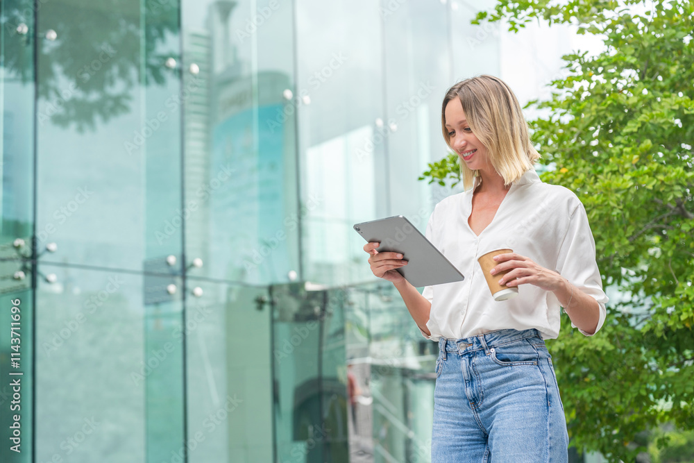 Caucasian Woman with Tablet While Having a Cup of Coffee In Front a Modern Glass Office Building Caucasian Woman with Tablet While Having a Cup of Coffee In Front a Modern Glass Office Building
