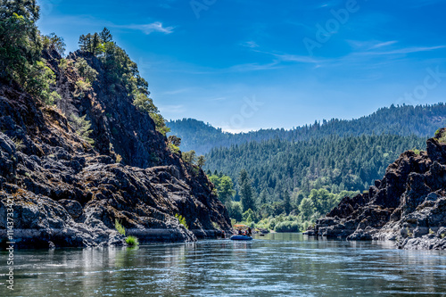 Wild and scenic Rogue River in Southern Oregon with a distant rafter floating. 