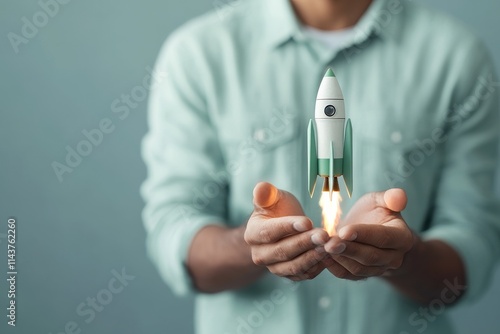 Wallpaper Mural A hand launches a small green rocket, symbolizing aspiration and innovation, set against a tranquil minimalist backdrop, illustrating a leap into the future. Torontodigital.ca