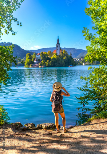 Fotografia Tourist admiring lake bled island with pilgrimage church of the assumption of ma