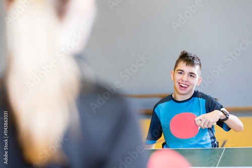 Wallpaper Mural Happy disabled boy playing table tennis with coach at sports court Torontodigital.ca