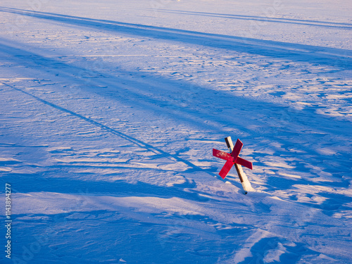 Red cross sign on snow covered land photo