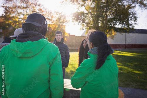 Volunteers in uniform convincing group of friends for social responsibilities photo