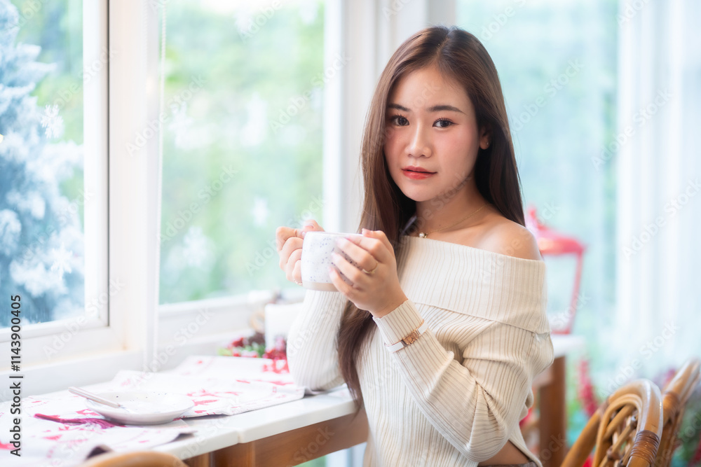 Portrait beautiful asian woman holding of positive the having cup of coffee,milk or chocolate at home in the living room indoors Decoration During Christmas x-mas and New Year holidays.